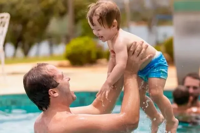 father playing with his son in the pool, narrow focus