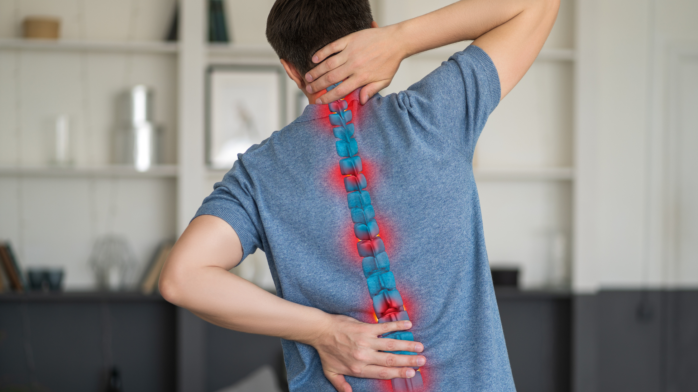 Person holding lower back from facet syndrome pain