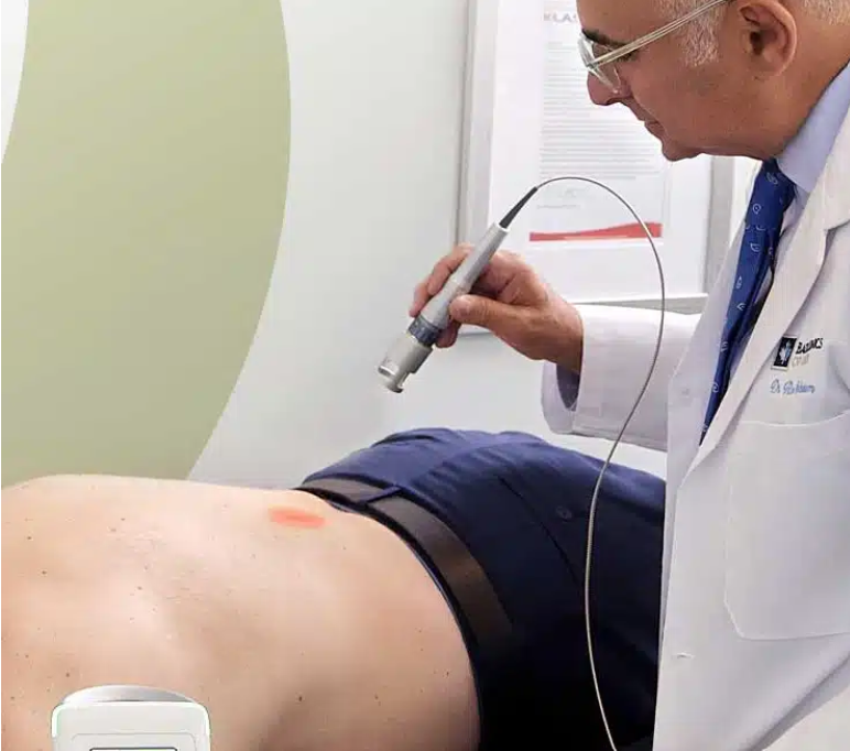 Dr. Ron Nusbaum applying Class IV laser therapy to a patient's back